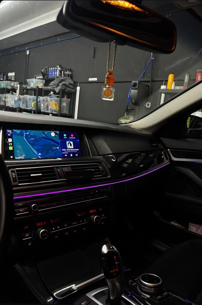 BMW 5er Cockpit mit nachgerüstetem CarPlay-Display und violettem Ambientelicht
